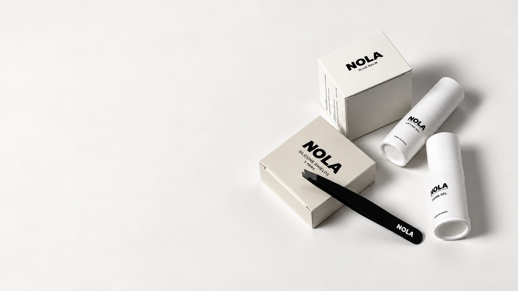 NOLA lash lift products arranged on a light studio surface