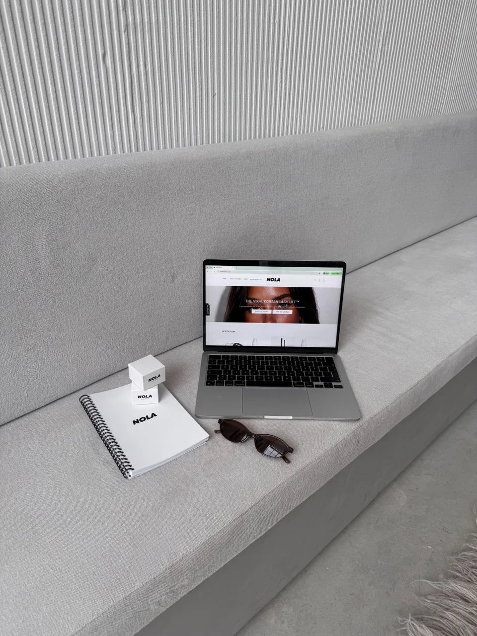 NOLA course workspace with a laptop, notebook and NOLA products